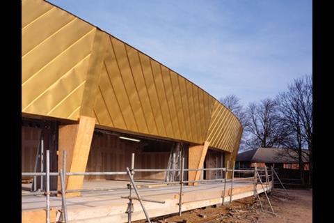 The walls and roof are clad in this gold-coloured copper and aluminium alloy sheet. The angle of the inclined walls varies all the way around the building